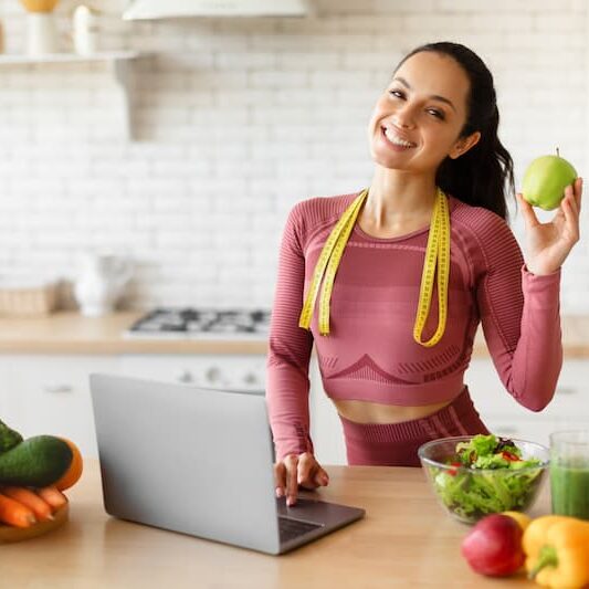 woman holding apple in workout clothes